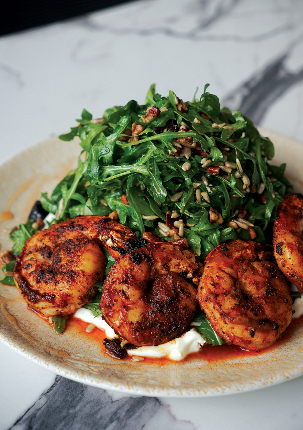 The Arugula Central makes greens the star. It’s topped with whipped goat cheese, spicy candied pecans, sunflower seeds, and figs. The salad, served with shrimp, has a shallot vinaigrette drizzle.