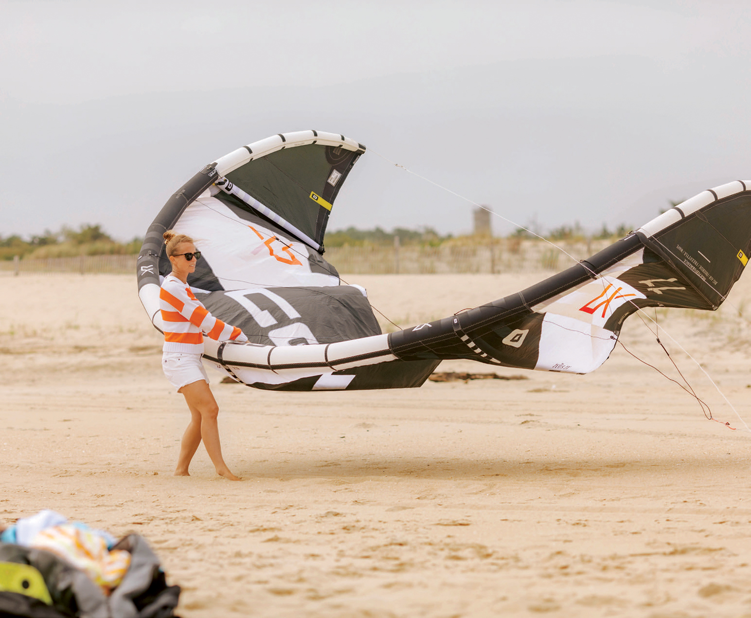Kyle Iskra helps her husband, Matt Snyder, gear up for a session. While Snyder has been kiting since he spent summers in Lewes as a kid, he recently taught the pastime to his wife, who convinced him women might be better suited for the sport. “[Women] don’t try to muscle it their own way. …It’s a balancing act and more of a dance than just exerting sheer power and forcing something to bend to your will,” he says.